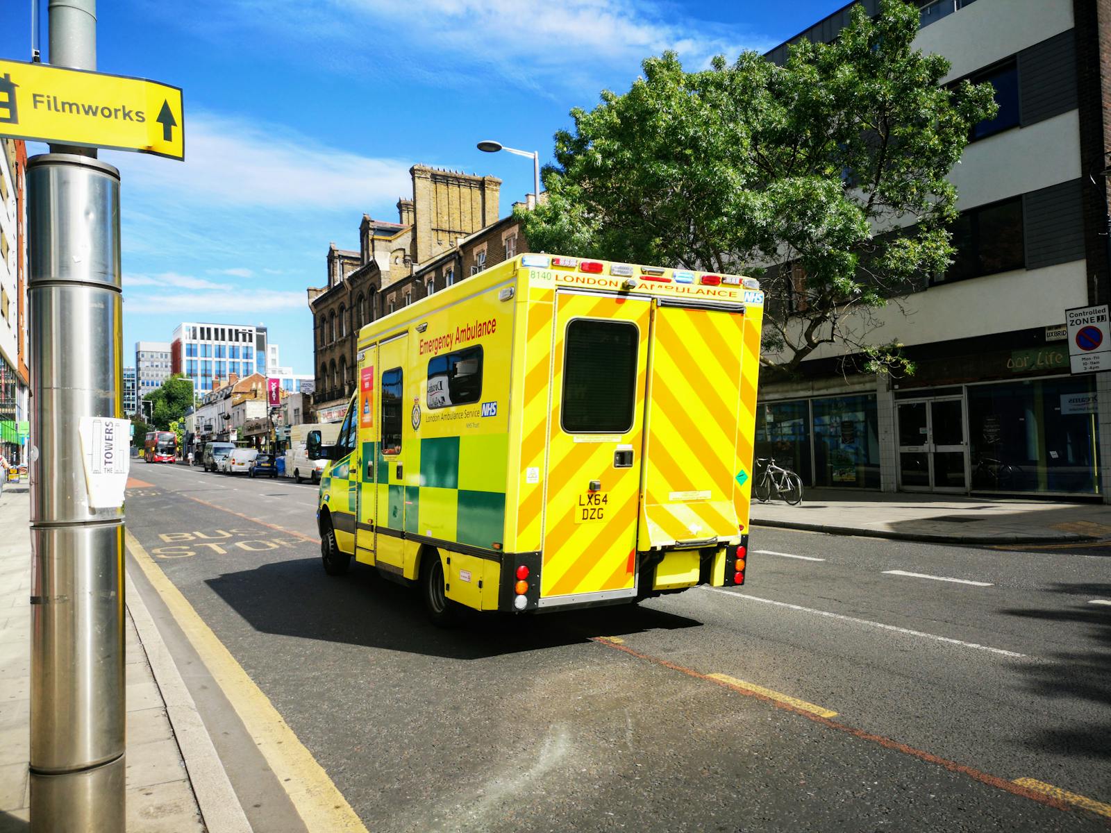 A London emergency ambulance driving through a city street in England, showcasing public health service.